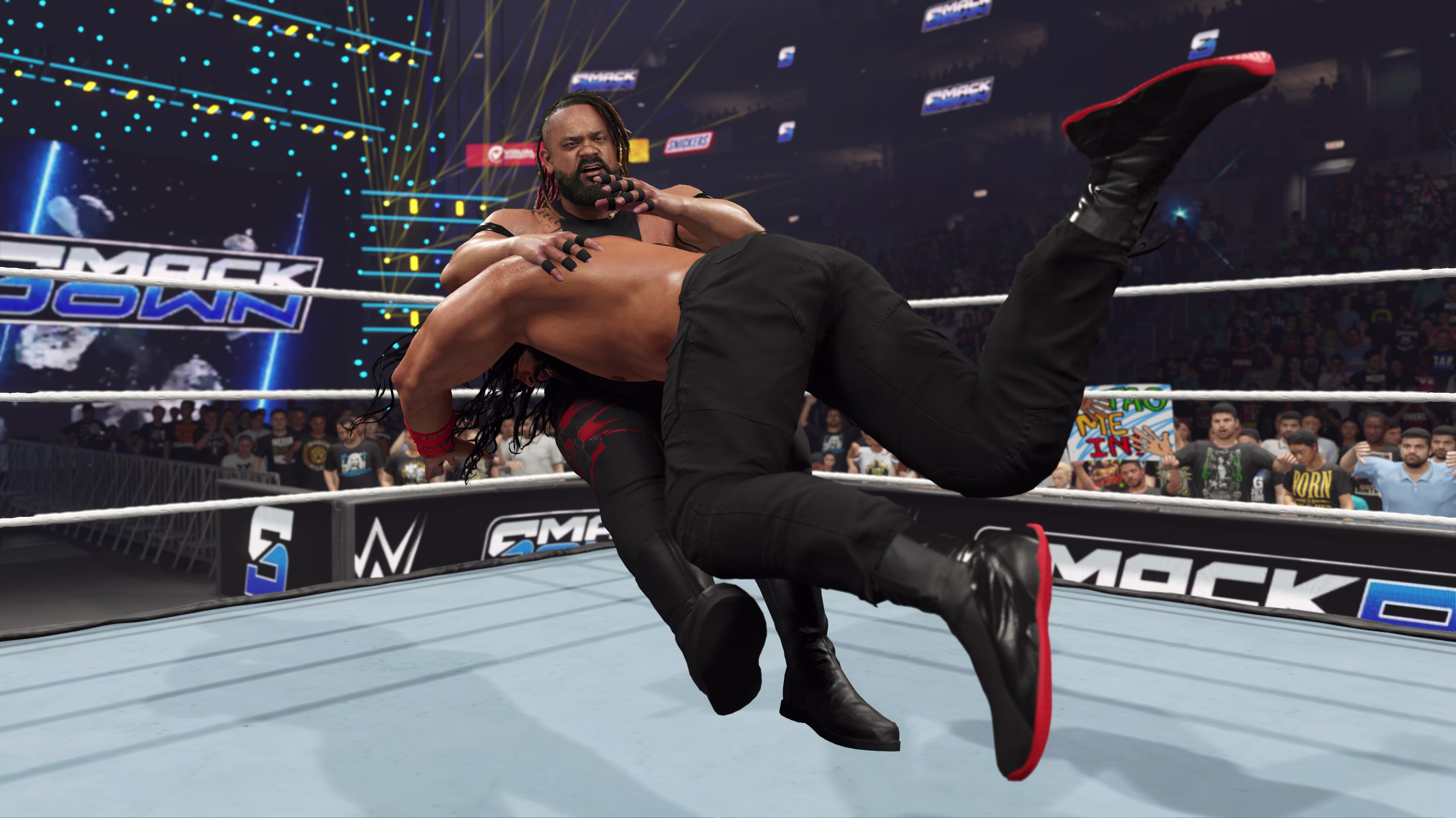 Roman Reigns führt einen Spear auf Jacob Fatu aus