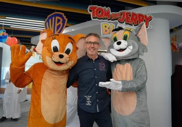 Ein Bild eines Mannes zwischen zwei Maskottchen, die jeweils als Tom und Jerry verkleidet sind